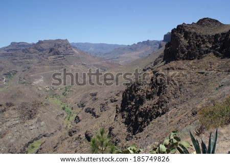 Arid canyon and barren landscape with vegetation in the river valley. Gran Canaria.