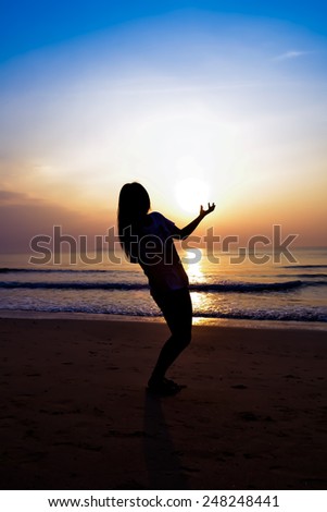silhouette of woman alone and wave on the beach with sunset in the sea