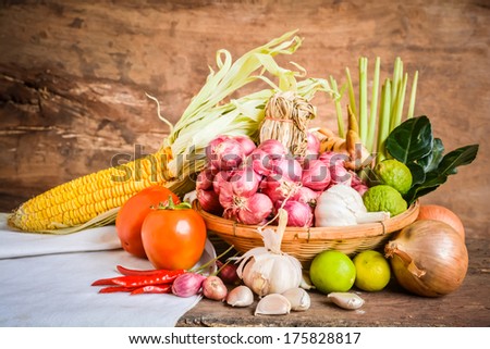Still life of mix vegetable arranged with basket and white fabrics place on old wooden
