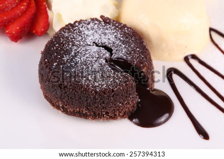 Ice cream, banana, strawberry, chocolate cake with chocolate sauce on white plate