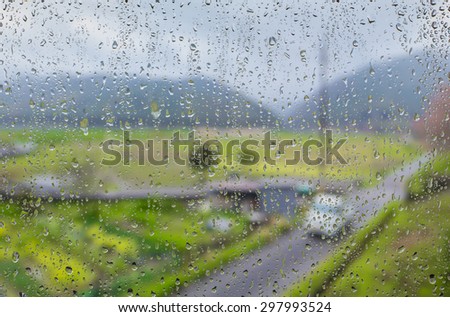 in raining day. A view of road and rural area from window outside