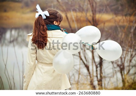 girl with white balloons in autumn