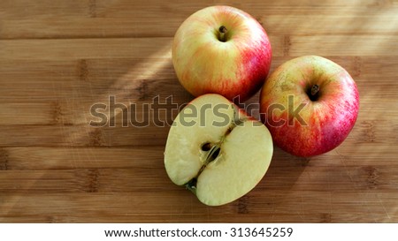 Apples and half apple on a table, outdoor setting, sunset light