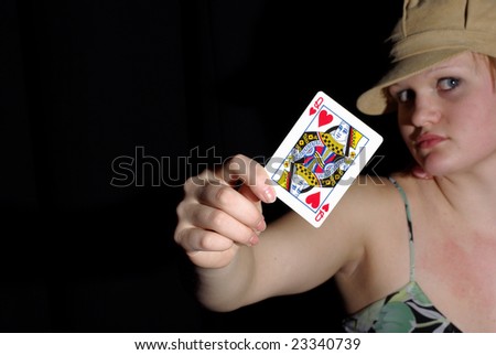 Expressive girl holds queen of hearts up. focus on card