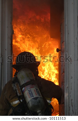 Firefighter entering burning house