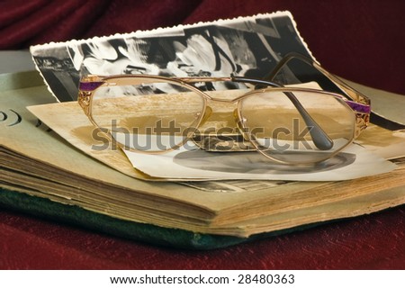 The old photo album , and  the glasses , on red background.