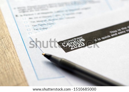 Closeup of United States Census 2020 form informational copy and a ballpoint pen on wooden background. Stockfoto © 
