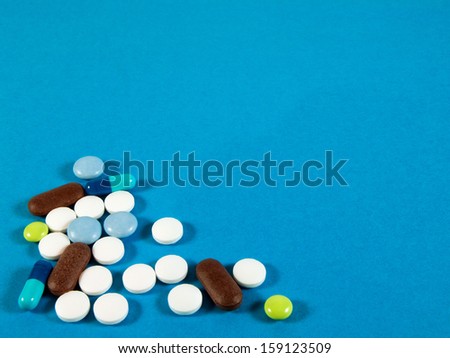 Colorful pills on blue background. Tablets with capsules. Medical background for your design.
