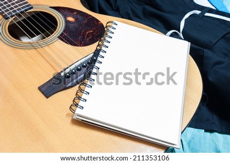 Notebook and pencil on guitar,Writing music
