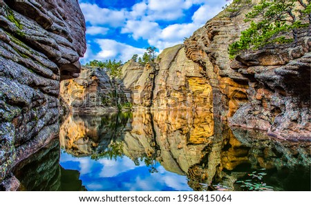 Reflection of water in a river canyon among the mountains. Cliffs are reflected in the water. Reflection in water scene