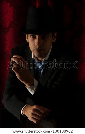 Retro man with hat smoking in night