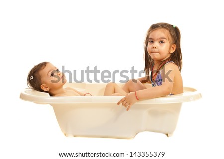 Two sisters dreaming with open eyes in a bath tub isolated on white background