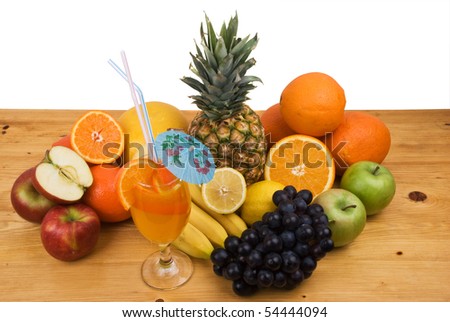 Variety of fresh fruits and a glass with juice on a wood table