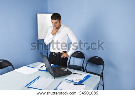 Worried or pensive  business man waiting in a meeting room for his colleagues and  holding his hand to face