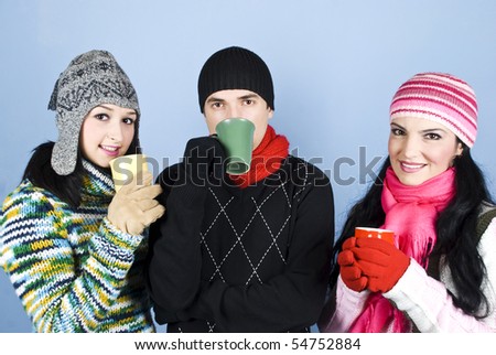 Happy group of friends drinking from mugs with tea and smiling over blue background