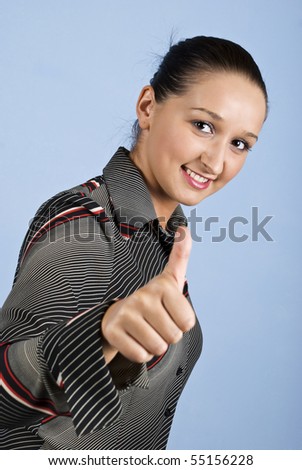 Young business woman give thumbs up and smiling isolated on blue background