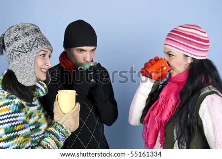 Group of young friends enjoying a hot drink and a conversation together ,they having a discussion,drinking  and smiling over blue background