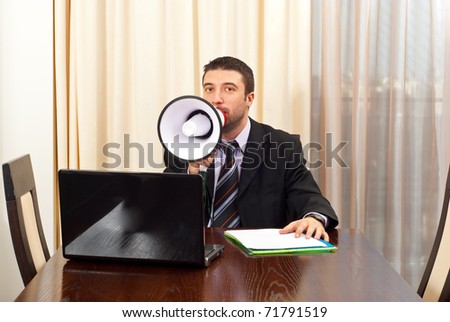 Manager man sitting on chair at meeting table and shouting megaphone