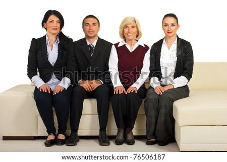 Group of four business people sitting on a beige couch in a line isolated on white background