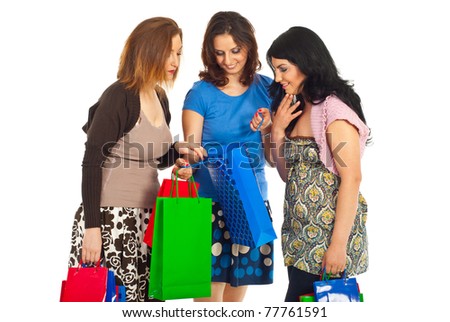 Three women friends looking and admiring  what they brought in a shopping bag isolated on white background