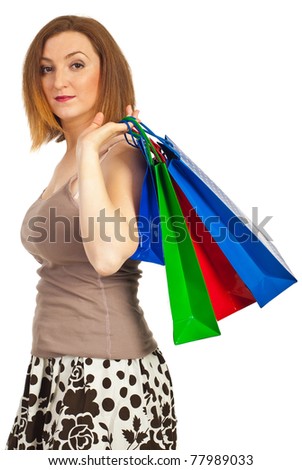 Redhead woman in profile holding colorful shopping bags on her shoulder isolated on white background