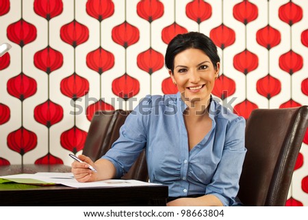 Happy executive woman  holding pencil and sitting at table meeting in modern office