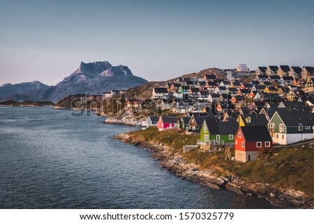 Nuuk capital of Greenland with Beautiful small colorful houses in myggedalen during Sunset Sunrise Midnight Sun. Sermitsiaq Mountain in Background. Blue and pink Sky.