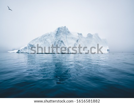 Iceberg and ice from glacier in arctic nature landscape in Ilulissat, Greenland. Aerial drone photo of icebergs in Ilulissat icefjord. Affected by climate change and global warming.