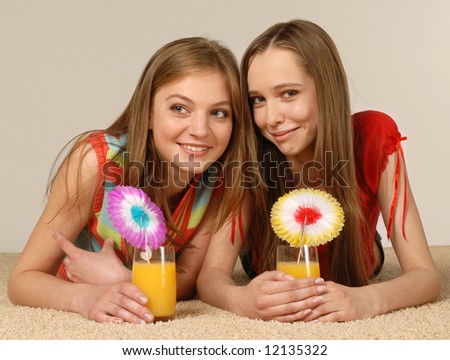 Two beautiful girls have a rest laying on a carpet