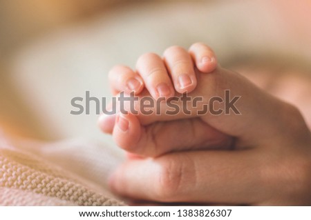 Female hand holding her newborn baby's hand. Mom with her child. Maternity, family, birth concept. Copy space for your text. Stock fotó © 