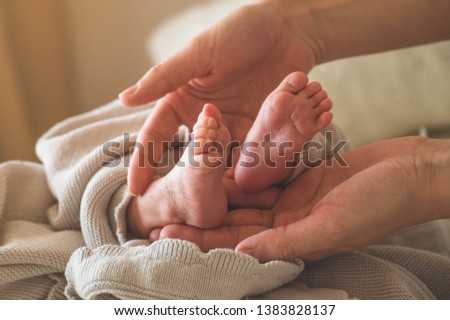 Female hand holding her newborn baby's legs. Mom with her child. Maternity, family, birth concept. Copy space for your text. Stock fotó © 