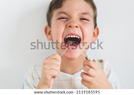 Similar – Image, Stock Photo Child flossing face and tiring milk tooth to pull out