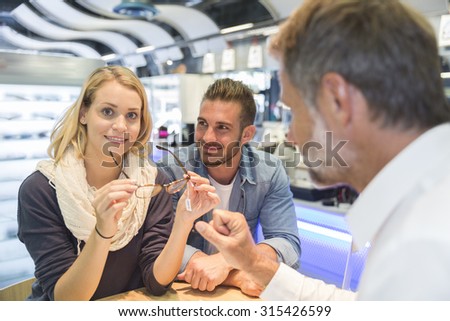 Woman in optical center trying eyeglasses on