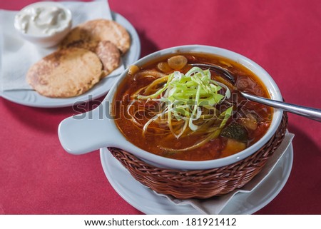 soup with cabbage in a wicker plate on a crimson background