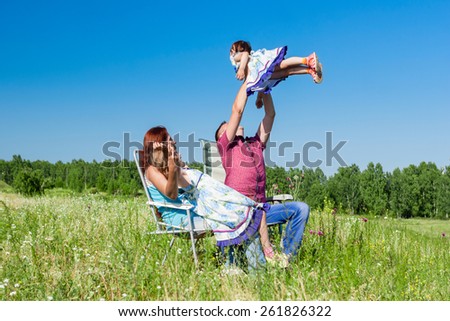 Outdoor portrait of a happy family. father picked up the child in her arms