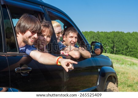 Outdoor portrait of young people looking out the window black car