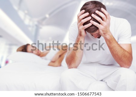 Blurred background of newlyweds have problems fighting in bed. Sleepy married couple have such serious health problem as erection & snoring. Wife is sulky & husband has erectile dysfunction. Stockfoto © 
