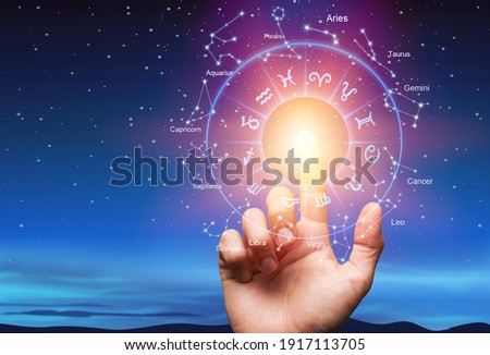 Astrological zodiac signs inside of horoscope circle with human hand