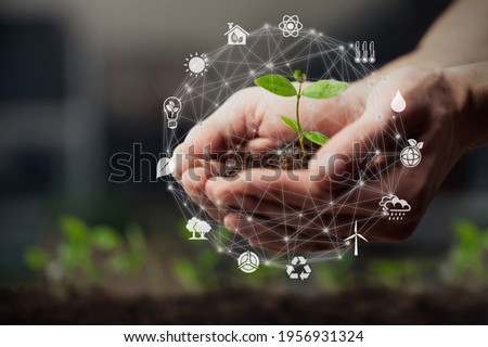 Hands using technology of renewable resources to reduce pollution and carbon emission .