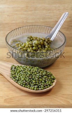 Mung beans in a wooden spoon and Mung bean boiled in a bowl on wooden background