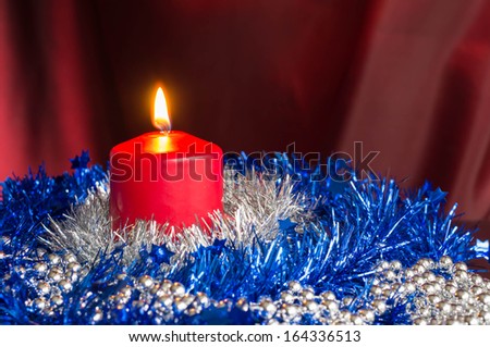 Red candle with a blue and silver Christmas decor
