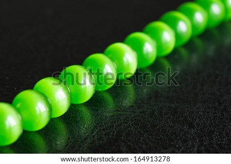 Chain of green beads on a black background