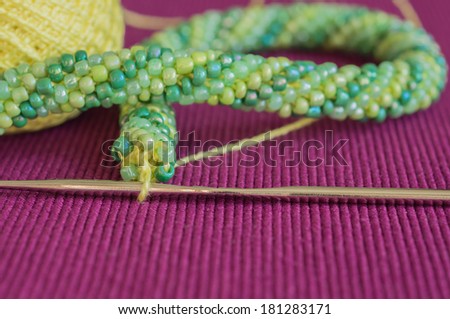 Knitted necklace from yellow and green beads