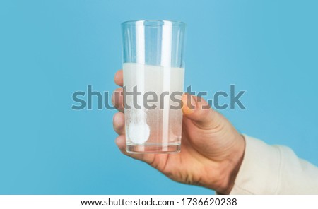 Glass of water tablet. Glass with efervescent tablet in water with bubbles. White pill and a glass of water in man hands. Health concept. Close up of man holding a pill. Imagine de stoc © 