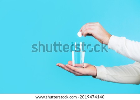 White pill and a glass of water in man hands. Health concept. Close up of man holding a pill. Glass of water tablet. Glass with efervescent tablet in water with bubbles. Imagine de stoc © 