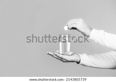 Health concept. Close up of man holding a pill. Glass of water tablet. Glass with efervescent tablet in water with bubbles. Black and white. Imagine de stoc © 