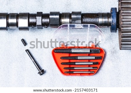 Bolt extractor, broken bolt, screw, stud extractor. Against the background of a disassembled camshaft of an internal combustion engine ストックフォト © 