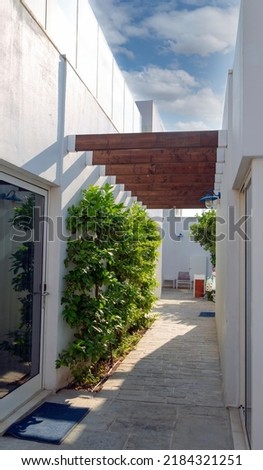 A narrow passage between the houses of the town. Narrow passage between white house's. Long narrow empty corridor between cottage. Passage to the courtyard between buildings with large windows on day Photo stock © 