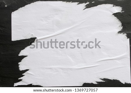 A sheet of white paper glued on a black wall. Foto stock © 