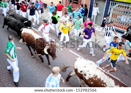 MADRID SUBURB OF SAN SEBASTIAN DE LOS REYES -SEPT. 30, 2013: Men run from the bulls on the street of San Sebastian de los Reyes during festival, Spain 2013. Fiesta called \